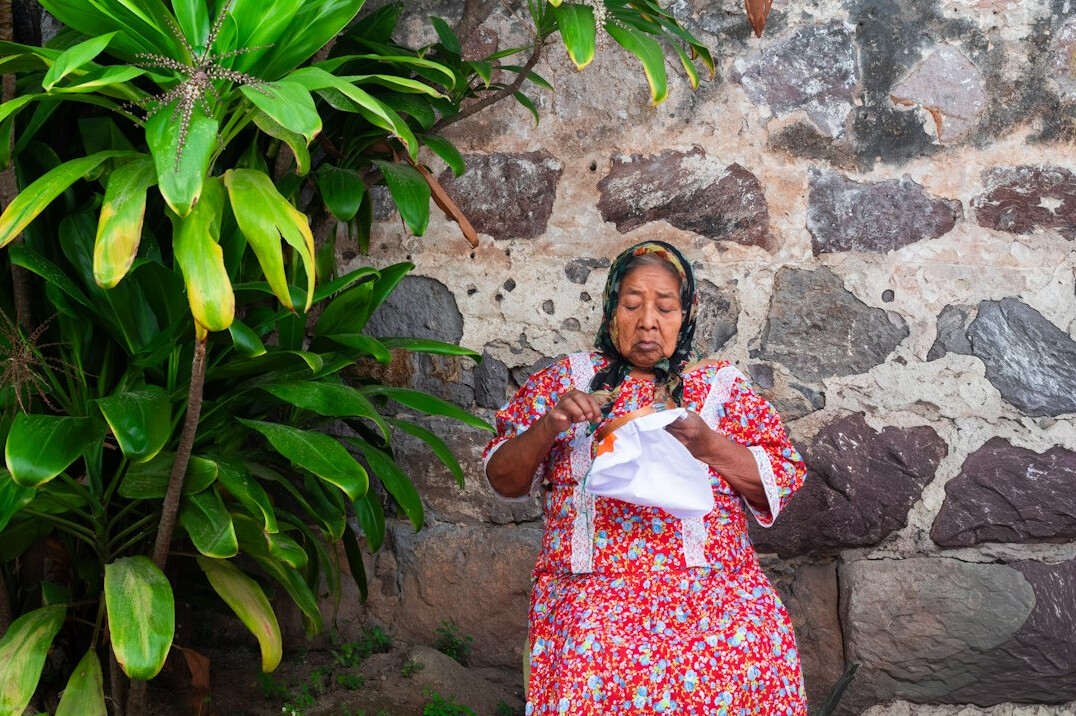 Mexican woman working with a calculator and notebook planning her finances