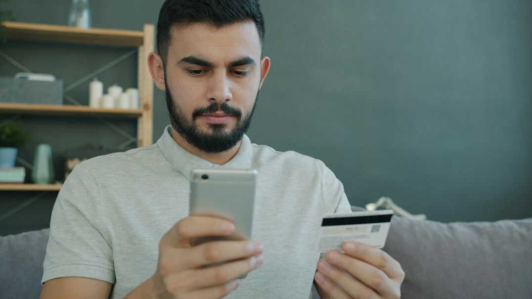 Hispanic man studying an online finance course on a tablet at home